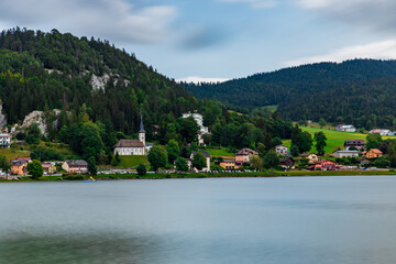 Fototapeta premium Long exposure bz the lake, Swiss alps and cathedral in Le Pond, Switzerland