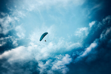 Paraglider flying in the cloudy sky