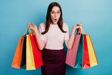 Photo of young girl amazed shock surprised hold shopping bags shopaholic isolated over teal...