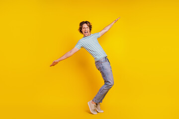 Full body profile side photo of young guy have fun hands wings playful isolated on yellow color background