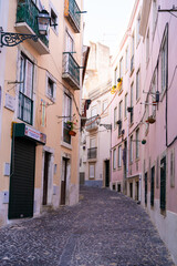 Fototapeta na wymiar Street with pastel color facades and cobblestone street