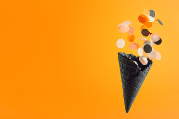 Black waffle ice-cream cone with multicolored confetti. Halloween holiday concept, Black Friday banner