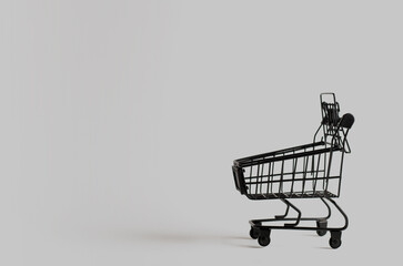 Black toy shopping cart on gray background with copy space. - 463839992