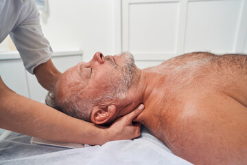 Obraz na płótnie Canvas Masseuse hands massaging male neck in spa salon