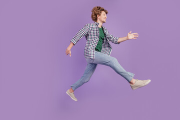 Full size profile side photo of young guy go walk hurry jump look empty space sale isolated over violet color background