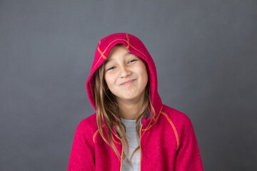 Portrait of a young happy girl in red sweater on grey background with space for text - 463842791