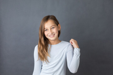 Portrait of a young happy girl on grey background with space for text - 463842792