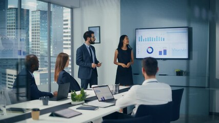 Diverse Office Conference Room Meeting: Team of Male Executive and Female Top Manager Present e-Commerce Startup Stock Market Growth Statistics to a Group of Investors. Wall TV with Infographics Data