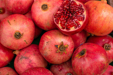 Pomegranate garnet fruit background pattern. Pomegranate whole with flower. Fresh raw organic garnet fruit pile texture background. Ruby natural pomegranate (garnet fruit) heap close up top view.