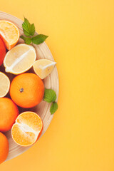 Composition of limns, tangerines and oranges on a yellow background.