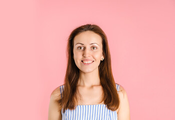 Portrait of a smiling woman on a pink background