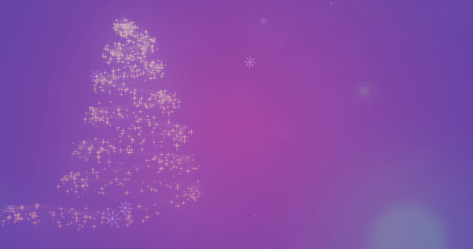 Image of snow falling over glowing christmas tree