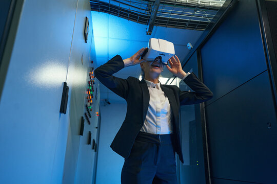 Young woman wearing virtual reality glasses indoors - Powered by Adobe