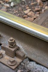 Closeup of increased lateral wear of steel rail with metal shavings in a very steep curve. Damage during increased operation of railway tracks