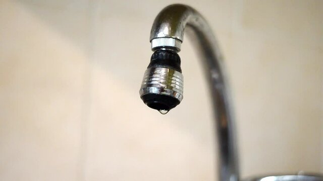 Concept of ecological problem of overconsumption of water. Dripping faucet. Water loss.