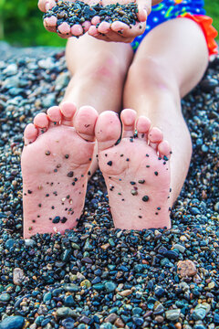 Child feet painted with paints on the sea. Selective focus.