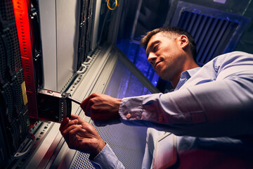 Concentrated engineer adding new HDD to server