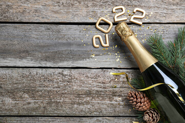 Happy New Year 2022! Flat lay composition with bottle of sparkling wine on wooden table, space for...