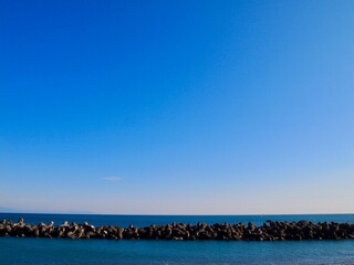 Fototapeta premium 水平線と青空とテトラポッド 海と空の背景