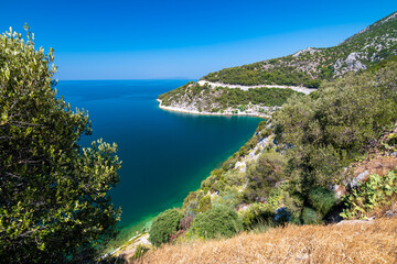 Fototapeta na wymiar View of beautiful Croatia coast near Makarska. Blue sea with white beach. Isles in the background. Summer weather, blue sky.