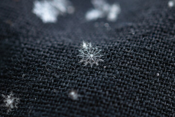 Snowflakes on the dark fabric material