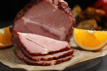 Cut delicious ham and orange on parchment paper, closeup