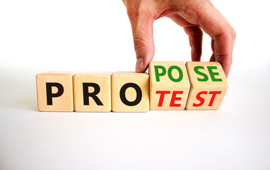 Propose instead protest symbol. Businessman turns wooden cubes, changes the word 'protest' to...
