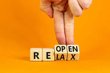 Relax and reopen symbol. Businessman turns cubes and changes the word 'relax' to 'reopen'. Beautiful orange table, orange background. Business, relax and reopen concept. Copy space.