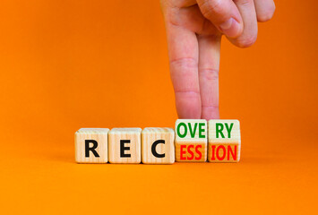 Recovery and recession symbol. Businessman turns cubes and changes the word 'recession' to 'recovery'. Beautiful orange table, orange background. Business and recovery - recession concept. Copy space.