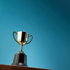 low angle view of winning trophy agaist blue background