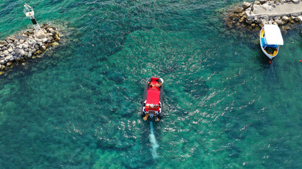 Aerial dronephoto of inflatable rigid power boat cruising in high speed in Mediterranean emerald bay