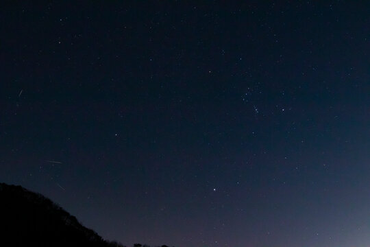 This is a picture of a winter night sky landscape. You can see the constellation Orion and the meteor showers in Gemini.