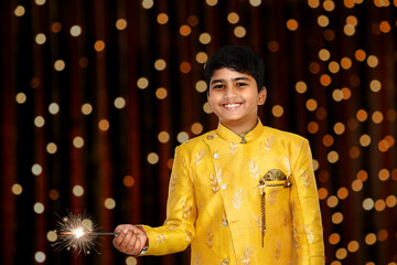 Indian Smart boy portrait in kurta holding Flare Stick on the occasion of diwali dark background