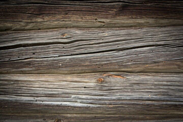 Fototapeta premium Wooden logs of an old house. Close-up. Weathered natural gray wood texture. Background. Horizontal photo.