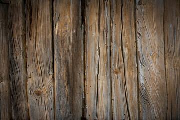 Fototapeta premium Wooden logs of an old house. Close-up. Weathered natural gray wood texture. Background. Horizontal photo.