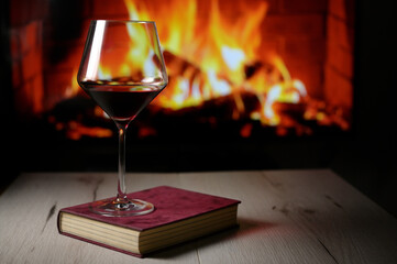 Dry Glass Of Red Wine, on Book and Fireplace