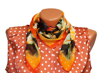 Women's silk scarf on a mannequin and pink jacket with white polka dots. shawl. On an isolated...