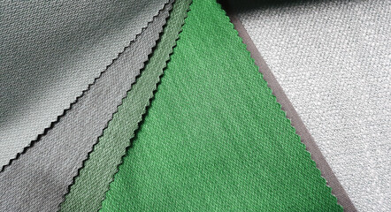 colorful bright fabric pattern palette texture samples in grey and green tone for interior material selection. matching color and texture of drapery material. close up upholstery catalog for choosing.