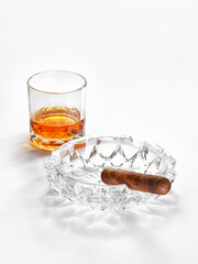 close up view of cuban cigar and glass of rum  aside on white back. 