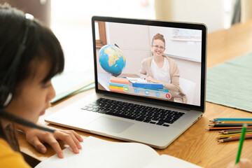 Fototapeta na wymiar Asian girl using laptop for video call, with smiling caucasian female teacher on screen