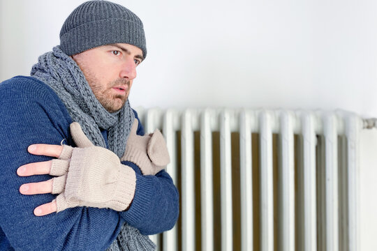 Man feeling cold at home with home heating trouble