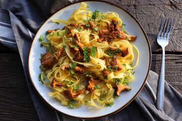 Tagliatelle pasta with fried in butter chanterelle mushrooms with garlic and finely chopped parsley...