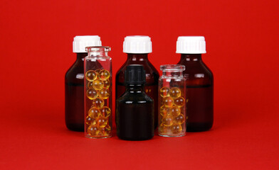 Different small medicine bottles on red background