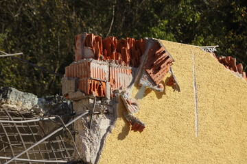 Abtragen einer Wand aus Ziegelsteinen mit einem Bagger
