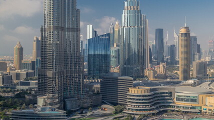 Skyscrapers rising above Dubai downtown timelapse, mall and fountain surrounded by modern buildings aerial top view