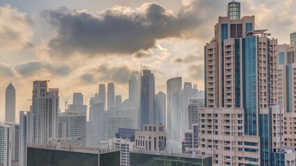 Dubai skyscrapers with golden sunset over business bay district timelapse.
