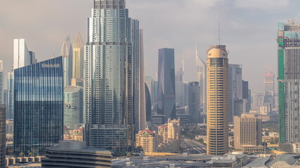 Fototapeta na wymiar Skyscrapers rising above Dubai downtown timelapse, mall and fountain surrounded by modern buildings aerial top view