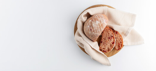 Sliced Italian vegetable bread on a light napkin and white background, banner, empty space for text