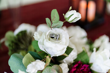 White gold ring with diamonds inside tender white rose petals Close up of elegant diamond ring inside white rose Marriage proposal Wedding concept Close up