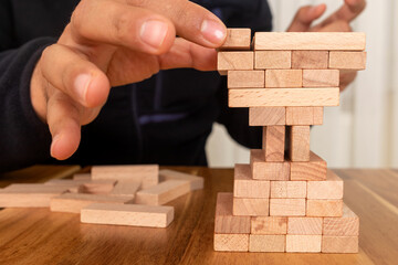 Man building wooden blocks shape of hour glass. Business and time management concept.